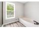 Bathroom featuring tile floors, large window and a modern soaking tub at 3 S Riversong Ln, Alpharetta, GA 30022