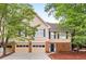 Charming exterior with a two-car garage, brick accents, well-maintained landscaping, and mature trees at 3 S Riversong Ln, Alpharetta, GA 30022