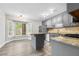 A modern kitchen featuring stainless steel appliances, light gray cabinets, granite countertops, and a center island at 3 S Riversong Ln, Alpharetta, GA 30022