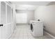 Bright laundry room featuring tile flooring, front load washer and dryer and natural light at 3 S Riversong Ln, Alpharetta, GA 30022