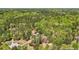 Expansive aerial view of a home surrounded by lush, mature trees with neighborhood homes afar at 45 Harvey Ave, Covington, GA 30016