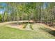 Lush backyard featuring a landscaped path and seating area surrounded by mature trees at 45 Harvey Ave, Covington, GA 30016