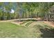 Grassy backyard with mature trees and a stone path leading to a bench at 45 Harvey Ave, Covington, GA 30016
