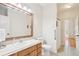 Well-lit bathroom featuring a sink, commode, grab bar, and tile flooring at 45 Harvey Ave, Covington, GA 30016