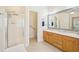 This bathroom includes a glass enclosed shower and a double vanity sink with wood cabinetry at 45 Harvey Ave, Covington, GA 30016