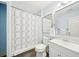 Well-lit bathroom with shower-tub combo, stylish white vanity, and modern patterned shower curtain at 45 Harvey Ave, Covington, GA 30016