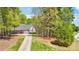 Long driveway leading to a brick home, surrounded by lush greenery and mature trees at 45 Harvey Ave, Covington, GA 30016
