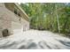 Home exterior featuring a three-car garage, long driveway, and wooded surroundings, offering functionality and privacy at 45 Harvey Ave, Covington, GA 30016