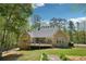 Rear exterior view with a spacious deck, well-manicured lawn, and mature trees at 45 Harvey Ave, Covington, GA 30016