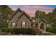 Charming brick home featuring a well-manicured lawn and mature landscaping at dusk at 45 Harvey Ave, Covington, GA 30016