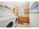 Bright laundry room with a modern washer and dryer, wooden cabinets, and tile flooring at 45 Harvey Ave, Covington, GA 30016