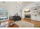 Open living room featuring fireplace, hardwood floors, and large windows overlooking deck at 45 Harvey Ave, Covington, GA 30016