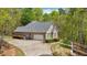 Side view showcasing the brick home, garage, and well-maintained landscaping in a wooded setting at 45 Harvey Ave, Covington, GA 30016