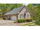 Side view showcasing the brick home, garage, and well-maintained landscaping in a wooded setting at 45 Harvey Ave, Covington, GA 30016