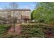 A landscaped backyard showcasing green shrubbery and the home's exterior with its balconies and patios at 4880 Payson Se Ter, Atlanta, GA 30339