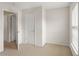 Empty bedroom featuring neutral walls and carpet with a window and white doors at 4880 Payson Se Ter, Atlanta, GA 30339