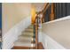 Inviting entryway with hardwood floors, wainscoting, carpeted stairs, and elegant wood and iron railing at 4880 Payson Se Ter, Atlanta, GA 30339