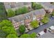 Aerial view of a row of brick townhomes with gray roofs, lush trees, and personal garages at 4880 Payson Se Ter, Atlanta, GA 30339
