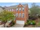 Lovely exterior elevation of a red brick townhome with an attached garage and well-maintained landscaping at 4880 Payson Se Ter, Atlanta, GA 30339