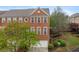 Charming three-story red brick townhome featuring an attached garage and beautiful landscaped surroundings at 4880 Payson Se Ter, Atlanta, GA 30339