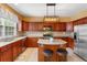 Gorgeous kitchen featuring stainless steel appliances, dark wood cabinets, kitchen island, and tile floors at 4880 Payson Se Ter, Atlanta, GA 30339