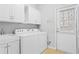 Laundry room with white washer and dryer, sink, and cabinets at 4880 Payson Se Ter, Atlanta, GA 30339