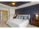 Spacious main bedroom featuring a tray ceiling, fan, and a calming blue accent wall at 4880 Payson Se Ter, Atlanta, GA 30339