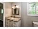 Bathroom vanity features granite countertops, bronze fixtures, and a framed mirror with a window providing natural light at 6497 King William Dr, Morrow, GA 30260