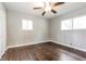 A light-filled bedroom features hardwood floors, two windows and a ceiling fan at 6497 King William Dr, Morrow, GA 30260