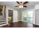 Bright room features hardwood floors, a ceiling fan, stairs, and access to the backyard deck at 6497 King William Dr, Morrow, GA 30260