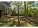 Large, fenced backyard featuring mature trees and a storage shed at 125 Valley View Ct, Tyrone, GA 30290