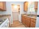 Cozy kitchen featuring wooden cabinets, neutral countertops and leads into a laundry area with a washing machine at 125 Valley View Ct, Tyrone, GA 30290