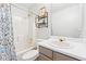 Bright bathroom featuring a tub with a shower, white fixtures, and decorative shelving for storage at 1433 Chardin Dr, Marietta, GA 30062