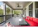 A covered porch with red sofa and wicker chairs offering a cozy space to relax and enjoy the outdoors at 185 Vandiver Ct, Acworth, GA 30101