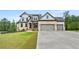 Impressive two-story home with a large driveway, three-car garage, and manicured lawn with lush landscaping at 185 Vandiver Ct, Acworth, GA 30101