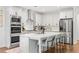 Modern kitchen with white cabinetry, stainless steel appliances, large island with seating, and hardwood floors at 185 Vandiver Ct, Acworth, GA 30101