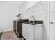 Laundry room featuring sleek black appliances and a utility sink with a granite countertop at 185 Vandiver Ct, Acworth, GA 30101