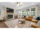 Cozy living room featuring a stone fireplace, large windows, hardwood floors, and stylish furniture at 185 Vandiver Ct, Acworth, GA 30101