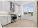Bright kitchen boasts white cabinetry, stainless steel appliances, and a large window with neighborhood views at 2842 Evanshire Ave # 113, Duluth, GA 30096