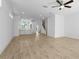Open-concept living room with kitchen, staircase, light wood floors, and ceiling fan at 2842 Evanshire Ave # 113, Duluth, GA 30096