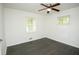 Bright bedroom with hardwood floors, a ceiling fan, two windows and white walls at 4322 Glenwood Pkwy, Decatur, GA 30032