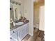 Bathroom featuring granite countertops, white cabinets, wood-look floors, and a shower-tub combo at 4460 Branchwood Ct, Loganville, GA 30052