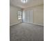 Unfurnished bedroom with plush gray carpeting, natural light from a window, and bi-fold closet doors at 4460 Branchwood Ct, Loganville, GA 30052