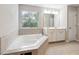 Bright bathroom features a soaking tub, double vanity, tile floor, and lots of light at 4528 Venus Sw Ct, Powder Springs, GA 30127