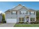 Charming two-story home with gray siding, a well-manicured lawn, and an attached two-car garage at 4528 Venus Sw Ct, Powder Springs, GA 30127
