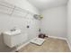 Functional laundry room with utility sink, tile floors, and shelving for storage at 4528 Venus Sw Ct, Powder Springs, GA 30127