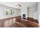 Bright living room features a fireplace, ceiling fan, and gleaming hardwood floors at 4528 Venus Sw Ct, Powder Springs, GA 30127