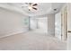 Spacious main bedroom featuring plush carpeting, tray ceilings, a ceiling fan, and an attached sitting room at 4528 Venus Sw Ct, Powder Springs, GA 30127