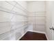 Spacious walk-in closet features custom shelving and dark hardwood floors at 4528 Venus Sw Ct, Powder Springs, GA 30127