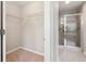 Bright walk-in closet features rod and shelf storage and opens to a glass shower at 4528 Venus Sw Ct, Powder Springs, GA 30127